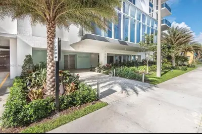 a palm tree in front of a building at Soñada vista al agua 3/3 in Miami
