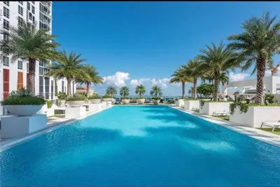 a large swimming pool with palm trees and buildings at Soñada vista al agua 3/3 in Miami