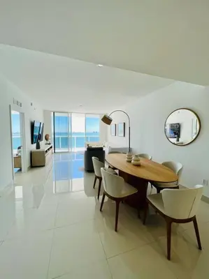a living room with a wooden table and chairs at Soñada vista al agua 3/3 in Miami