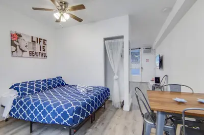 a room with a bed and a table and a ceiling fan at Private Ocean Dr Apt w/2 Queen Beds, Steps 2 Beach in Miami Beach