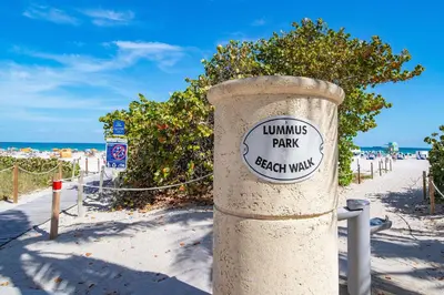 a pole with a sign on it on the beach at Super Beach Deal, Apt w/2 Queen Beds On Ocean Dr in Miami Beach