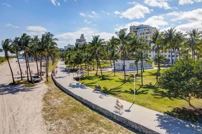 a park with palm trees and a sidewalk at Super Beach Deal, Apt w/2 Queen Beds On Ocean Dr in Miami Beach