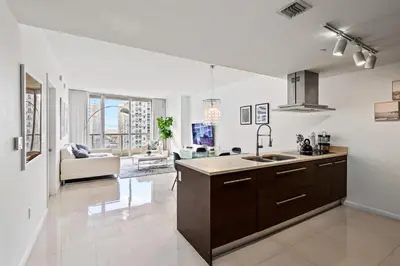 a kitchen with a sink and a living room at Modern High Rise One Bedroom at Icon Brickell (W) in Miami