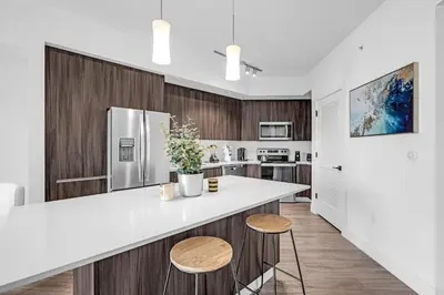 a kitchen with a white counter and wooden cabinets at Tranquil 1 Bed Escape in Doral With Free Parking in Hialeah Gardens
