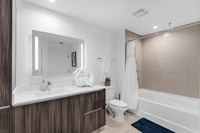 a bathroom with a tub and a toilet and a sink at Sleek Doral Retreat 1 Bed Oasis With Free Parking in Hialeah Gardens