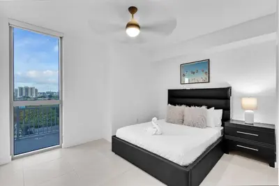 a bedroom with a bed and a large window at Charming 3-Bed Mins from Brickell With Free Parking in Miami
