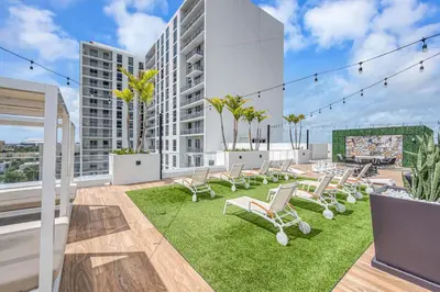 a patio with chairs and grass on a building at Charming 3-Bed Mins from Brickell With Free Parking in Miami