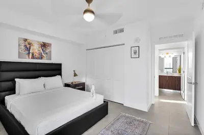 a white bedroom with a large bed and a bathroom at Gorgeous 3-Bed Retreat Mins from Bayside and Parking in Miami