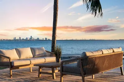 a couch sitting on a deck next to the water at Villa Hashmi Luxury 5BD & 5BA Retreat on North Bay Island in Miami Beach