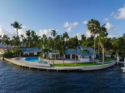 a house on the water with palm trees at Villa Hashmi Luxury 5BD & 5BA Retreat on North Bay Island in Miami Beach