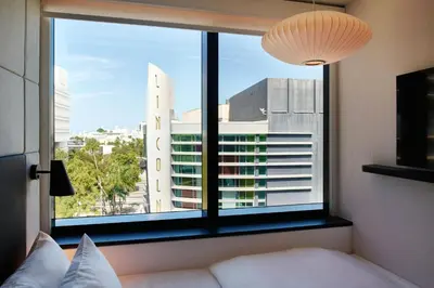 a bedroom with a large window with a view of a city at citizenM Miami South Beach in Miami Beach