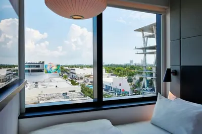 a bedroom with a large window with a view of a city at citizenM Miami South Beach in Miami Beach