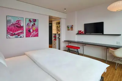 a bedroom with a bed and a desk and a television at citizenM Miami South Beach in Miami Beach
