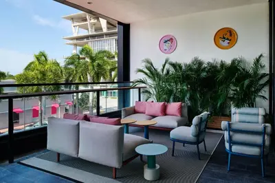 a living room with chairs and tables and a balcony at citizenM Miami South Beach in Miami Beach