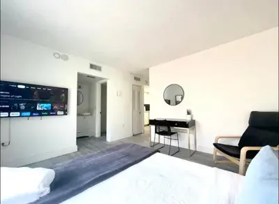 a bedroom with a bed and a living room with a piano at Miami International Airport 1 in Miami