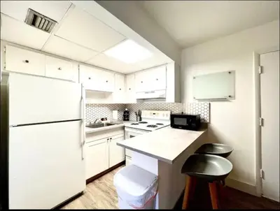 a kitchen with white cabinets and a white refrigerator at Miami International Airport 1 in Miami
