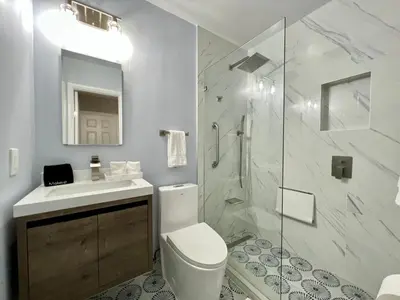 a bathroom with a toilet and a sink and a shower at Villa Michloe - Steps from Wilton Drive in Fort Lauderdale