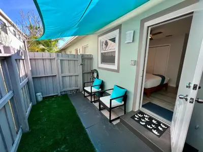 a small porch with two chairs and a bedroom at Villa Michloe - Steps from Wilton Drive in Fort Lauderdale