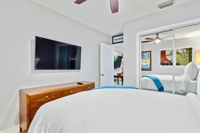 a white bedroom with a bed and a tv at Wilton Manors 2BR Charm! Walk to the Drive in Fort Lauderdale