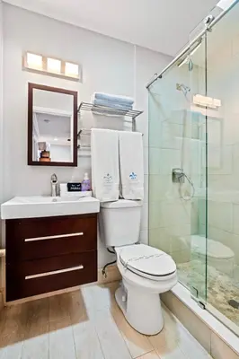 a bathroom with a toilet and a glass shower at Wilton Manors 2BR Charm! Walk to the Drive in Fort Lauderdale