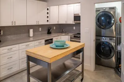 a kitchen with white cabinets and a table with a bowl on it at Walk to Wilton Drive - Spacious & Quiet Villa #2 HOT TUB! in Fort Lauderdale