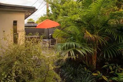 a garden with an orange umbrella and some plants at Walk to Wilton Drive - Spacious & Quiet Villa #2 HOT TUB! in Fort Lauderdale