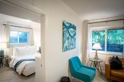 a bedroom with a bed and a blue chair at Walk to Wilton Drive - Spacious & Quiet Villa #1 in Fort Lauderdale