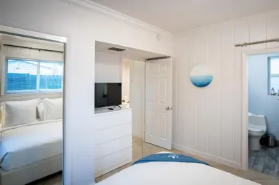a white bedroom with a bed and a television at Walk to Wilton Drive - Spacious & Quiet Villa #1 in Fort Lauderdale