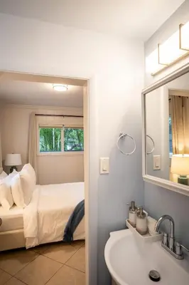 a bathroom with a bed and a sink and a mirror at Walk to Wilton Drive - Spacious & Quiet Villa #1 in Fort Lauderdale
