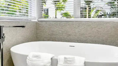 a white bath tub in a bathroom with a window at Villa Tropicale Stunning 4 Bedroom 4 Bath Home with Pool and BBQ in Miami