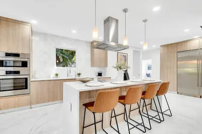 a kitchen with a island with a bar with chairs at Villa Tropicale Stunning 4 Bedroom 4 Bath Home with Pool and BBQ in Miami