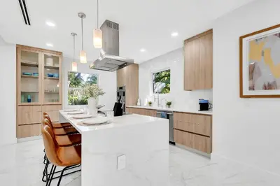 a kitchen with a white counter top and wooden cabinets at Villa Tropicale Stunning 4 Bedroom 4 Bath Home with Pool and BBQ in Miami