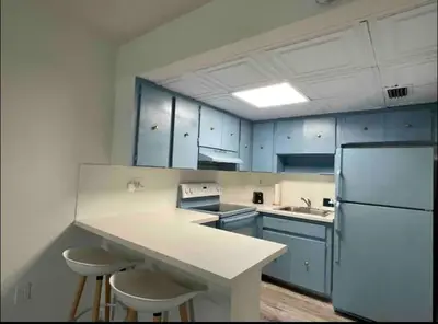 a kitchen with blue cabinets and a white refrigerator at Miami International Airport 2 in Miami