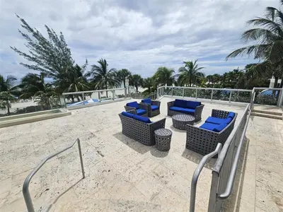 a group of chairs and tables on a beach at Mare-1708 A in Aventura