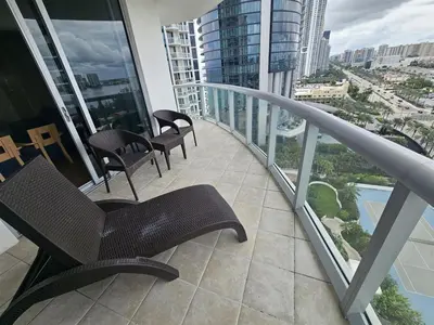 a balcony with chairs and tables on a building at Mare-1708 A in Aventura