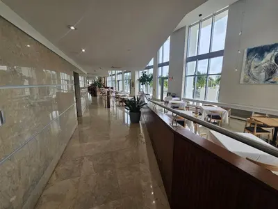 a restaurant with a long hallway with tables and windows at Mare-1708 B in Aventura