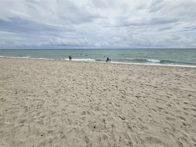 a group of people walking on the beach at Mare-1708 B in Aventura