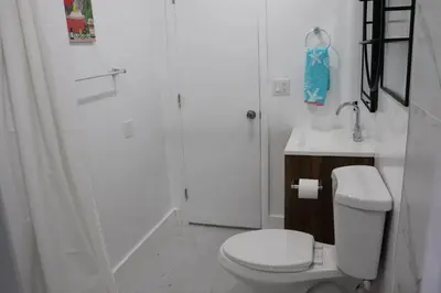 a white bathroom with a toilet and a shower at Flamingo Beach House in Dania Beach
