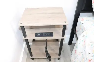 a nightstand with a clock on it next to a bed at Flamingo Beach House in Dania Beach