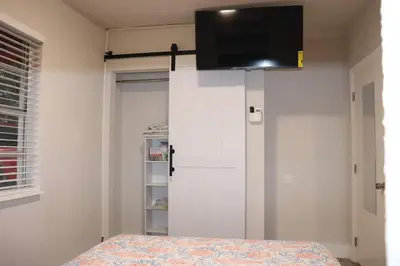 a bedroom with a white cabinet with a television on it at Flamingo Beach House in Dania Beach