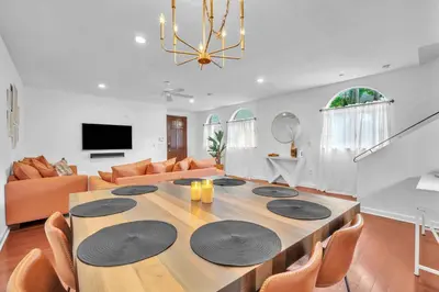 a living room with a large wooden table with chairs at Center Grove - Lush & Spacious & New - 3 Bedrooms in Miami