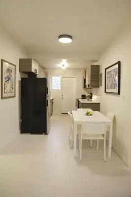 a kitchen with a white table and a black refrigerator at Apt 2 Miami Designer Apartment in the Upper East-Side in Miami