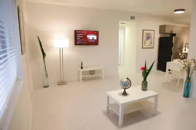 a living room with a table and a tv on the wall at Apt 2 Miami Designer Apartment in the Upper East-Side in Miami
