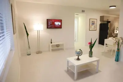 a living room with a table and a tv on the wall at Apt 4 Miami Designer Apartment in the Upper East-Side in Miami