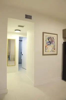 a white hallway with a painting on a wall at Apt 4 Miami Designer Apartment in the Upper East-Side in Miami