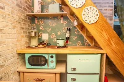 a small kitchen with a microwave and a stove at Miami Tiny Vintage Cottage in Hialeah