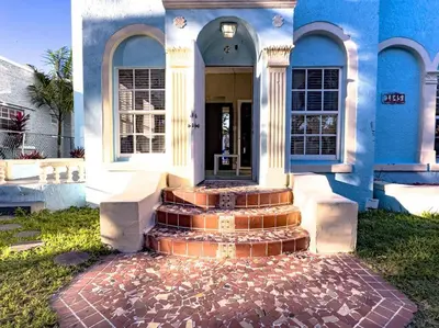 a blue house with stairs leading to the front door at Shenandoah Victorian Suite with TV's in every room in Miami