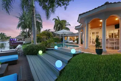 a house with a wooden deck with lights on it at Infinity Luxury Waterfront Infinity Pool and Hot Tub SLEEPS 8 in Fort Lauderdale