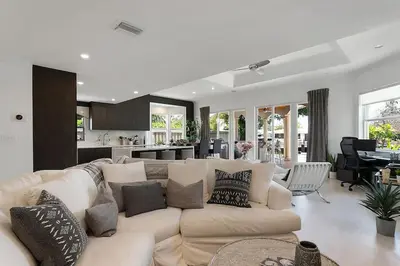 a living room with a white couch and a kitchen at Infinity Luxury Waterfront Infinity Pool and Hot Tub SLEEPS 8 in Fort Lauderdale