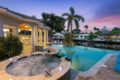 a large swimming pool in front of a house at Infinity Luxury Waterfront Infinity Pool and Hot Tub SLEEPS 8 in Fort Lauderdale